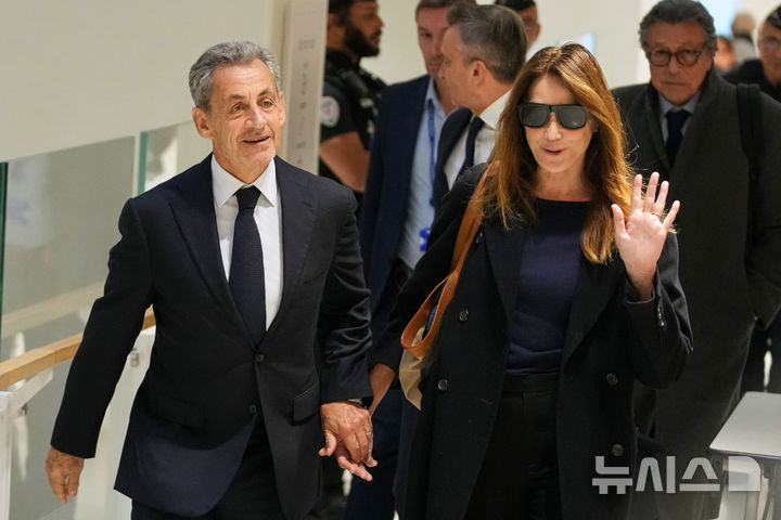 [AP/뉴시스] 프랑스의 니콜라 사르코지 전 대통령이 25일 2007년 대선 때 가다피로부터 불법선거 자금을 받은 혐의 재판의 선고을 앞두고 부인과 손잡고 법정에 들어서고 있다. 세 아들이 동행했으며 사르코지의 3번째 부패 재판인 가다피 사건에는 사르코지와 전 장관 3명 등 피고인이 모두 12명에 이른다.