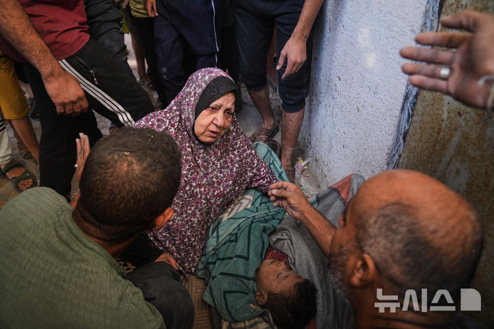 [AP/뉴시스] 25일 가자 중부 자와이다에서 이스라엘 공습에 죽은 12살 소년 시신을 가족들이 둘러싸고 있다