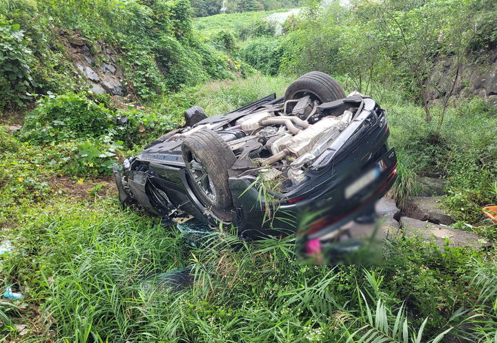 [부산=뉴시스] 25일 오전 3시께 부산 기장군 철마면 홍연폭포 입구 도로에서 스포츠유틸리티차량(SUV)이 가드레일을 들이받고 약 6ｍ 아래 하천으로 떨어진 뒤 전복됐다. (사진=부산경찰청 제공) 2025.09.25. photo@newsis.com *재판매 및 DB 금지