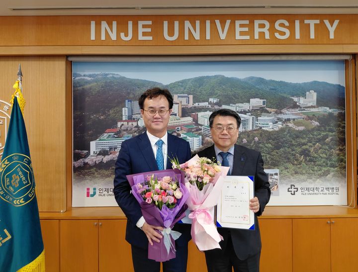 [양산=뉴시스] 김성훈(왼쪽) 신임 인제대 특임교수가 인제대학교 전민현 총장으로부터 특임교수 위촉장을 수여 받고 기념촬영을 하고 있다. (사진=김성훈 인제대학교 특임교수 제공) 2025.09.25. photo@newsis.com *재판매 및 DB 금지