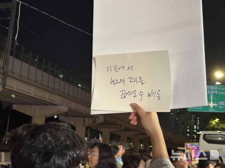 [서울=뉴시스] 한이재 기자 = 25일 오후 서울 구로구 대림역 인근에서 열린 '혐오 선동 규탄! 근본 대책 촉구! 기자회견' 참가자가 든 피켓 뒤에 "이곳에서 혐오의 고리를 끊어낼 수 있기를"이라 적힌 손 글씨가 보이고 있다. 2025.09.25. nowone@newsis.com
