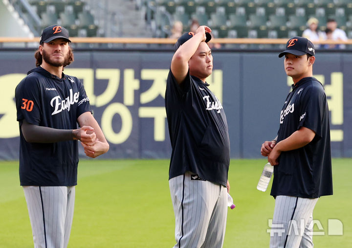 [서울=뉴시스] 조성우 기자 = 25일 오후 서울 송파구 잠실야구장에서 열린 2025 KBO리그 한화 이글스와 두산 베어스의 경기에 앞서 오는 주말 LG 3연전 선발로 예고된 한화 투수 류현진(가운데), 문동주(오른쪽), 폰세가 그라운드에서 몸을 풀고 있다. 2025.09.25. xconfind@newsis.com