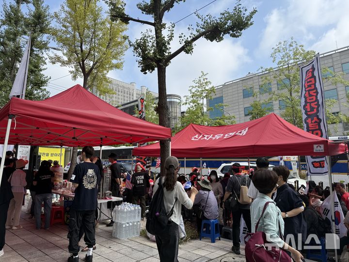[서울=뉴시스]이수린 수습기자=26일 오전 서울 서초구 서울중앙지법 인근에서 열린 윤석열 전 대통령 지지 집회에서 보수 성향 단체 신자유연대가 붉은 천막을 설치하고 참가자들이 모여 있다.2025.09.26
