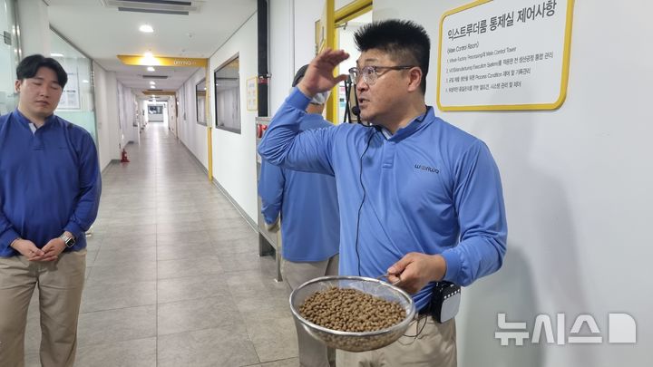 [음성=뉴시스] 임하은 기자 = 윤관식 우리와 생산팀 팀장이 25일 공정 과정에서 갓 나온 사료를 들고 설명하고 있다. rainy71@newsis.com 2025.09.26. 
