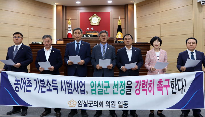 [임실=뉴시스] 26일 페회한 임실군의회 제348회 임시회, 왼쪽부터 김종규·양주영·장종민·김왕중·김정흠·정일윤·이성재 군의원이 임실군의 '농어촌 기본소득 시범사업' 대상지 선정을 촉구하고 있다. *재판매 및 DB 금지