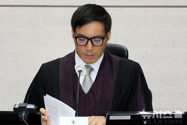 [서울=뉴시스] 사진공동취재단 = 윤석열 전 대통령의 특수공무집행방해, 직권남용 권리행사방해 등 혐의 사건 첫 공판이 열린 26일 서울 서초구 서울중앙지법에서 백대현 부장판사가 자료를 살펴보고 있다. 2025.09.26. photo@newsis.com