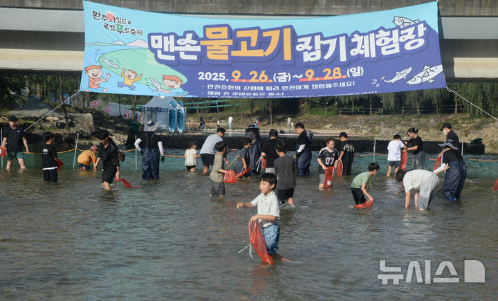 [완주=뉴시스] 김얼 기자 = 제13회 완주와일드&로컬푸드축제가 개막한 26일 전북 완주군 고산자연휴양림 일원 축제장을 찾은 시민들이 맨손 물고기잡기 체험을 하고 있다. 2025.09.26. pmkeul@newsis.com