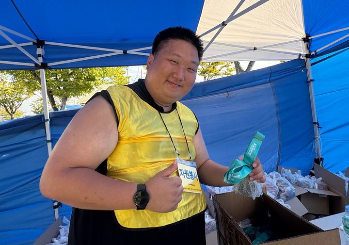 [인천=뉴시스] 신유림 기자=국내 최대 민영 뉴스통신사 뉴시스가 주최하고, 로드 스포츠가 주관하며, 인천광역시 중구청과 대한체육회가 후원하는 '제 1회 뉴시스 바다 마라톤'의 '자원봉사자 한영석 씨가 27일 인천광역시 영종도 하늘구름광장에서 펼쳐진 대회에 참석해 엄지를 들고 있다. 2025.09.27. spicy@newsis.com *재판매 및 DB 금지