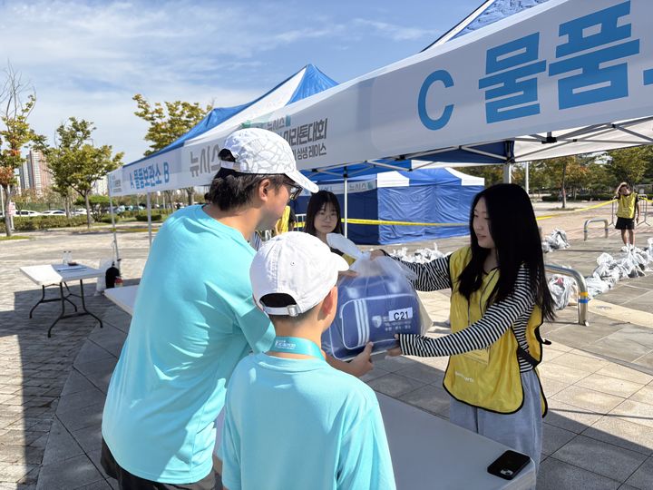 [인천=뉴시스] 신유림 기자=국내 최대 민영 뉴스통신사 뉴시스가 주최하고, 로드 스포츠가 주관하며, 인천광역시 중구청과 대한체육회가 후원하는 '제 1회 뉴시스 바다 마라톤'의 중학생 자원봉사자 김다솜 양과 방은경 양이 27일 인천광역시 영종도 하늘구름광장에서 펼쳐진 대회 물품보관대에서 참가자들에게 짐을 전달하고 있다. 2025.09.27. spicy@newsis.com *재판매 및 DB 금지 *재판매 및 DB 금지