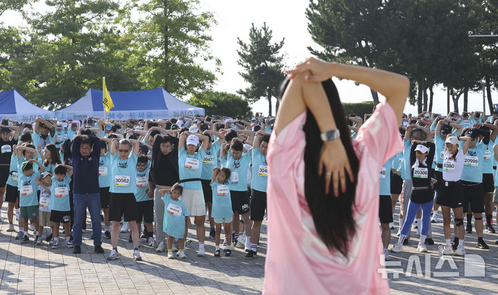 [인천=뉴시스] 박주성 기자 = 홍선근 뉴시스 회장을 비롯한 참가자들이 27일 인천 중구 씨사이드파크 하늘구름광장에서 열린 제1회 뉴시스 바다마라톤 대회에서 준비운동을 하고 있다. 2025.09.27. park7691@newsis.com