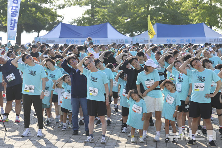 [인천=뉴시스] 박주성 기자 = 홍선근 뉴시스 회장을 비롯한 참가자들이 27일 인천 중구 씨사이드파크 하늘구름광장에서 열린 제1회 뉴시스 바다마라톤 대회에서 준비운동을 하고 있다. 2025.09.27. park7691@newsis.com