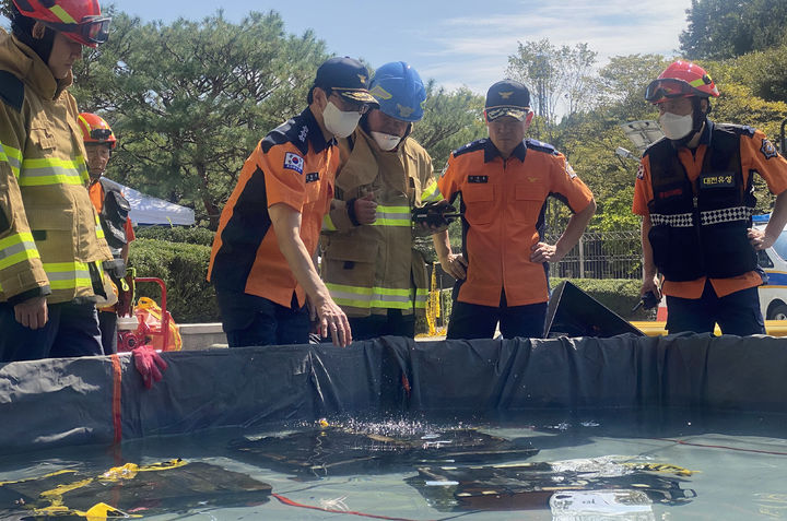 [대전=뉴시스] 강종민 기자 = 김승룡 소방청장 직무대행이 27일 대전시 유성구 국가정보자원관리원 화재 현장에서 소화수조에 담긴 불에 탄 리튬이온 배터리를 살펴보고 있다. (사진=소방청 제공) 2025.09.27. photo@newsis.com *재판매 및 DB 금지