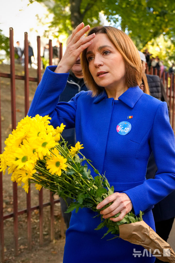 [AP/뉴시스] 몰도바의 친서방 마이아 산두 대통령이 28일 총선 투표를 마치고 부케을 들고 투표소를 나서고 있다