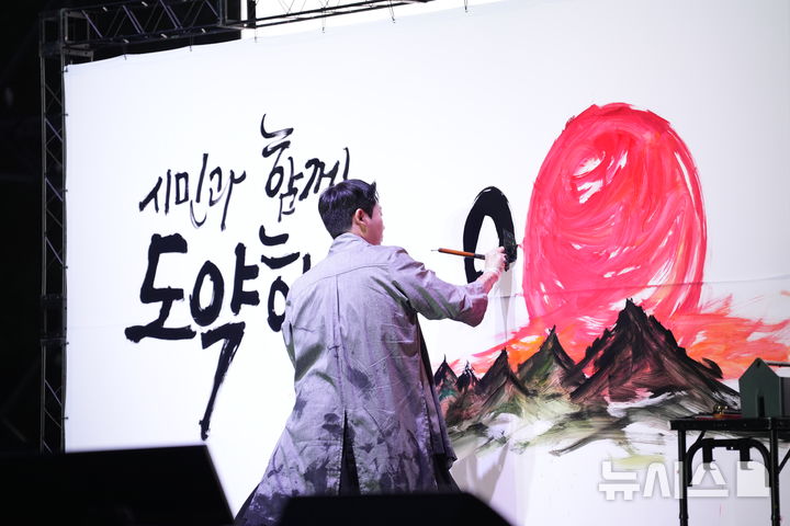 [안양=뉴시스] 서예가 김무진 작가가 붓을 이용해 글씨 써 내려가는 등 화려한 손놀림을 펼치고 있다. (사진=안양시 제공).2025.09.27. photo@newsis.com