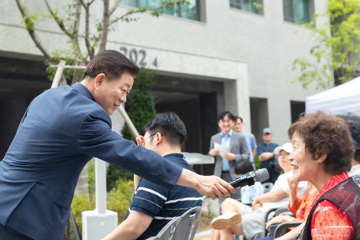 [광명=뉴시스]박승원 광명시장이 27일 호반써밋그랜드에비뉴 아파트에서 열린 시민 소통 프로그램 '아주 소중한 만남의 하루'에서 의견을 말하겠다는 시민에게 마이크를 대주고 있다.(사진=광명시 제공)2025.09.28.photo@newsis.com *재판매 및 DB 금지