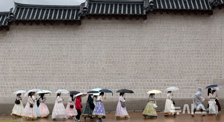 [서울=뉴시스] 추상철 기자 = 가을비가 내린 28일 오전 서울 종로구 광화문 앞에서 한복을 입고 우산을 쓴 외국인 관광객이 발걸음을 재촉하고 있다. 2025.09.28. scchoo@newsis.com
