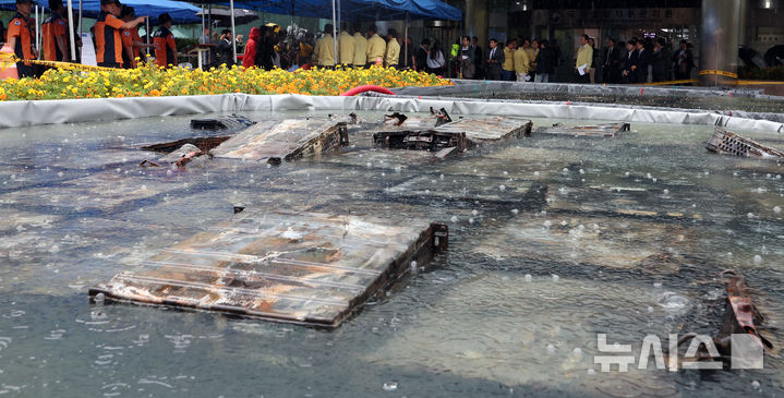 [대전=뉴시스] 강종민 기자 = 지난 28일 화재가 완진된 대전 유성구 국가정보자원관리원. 외부 침수조에 냉각작업 중인 리튬이온 배터리 위로 빗방울이 떨어지고 있다. 2025.09.28. ppkjm@newsis.com