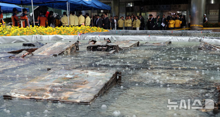 [대전=뉴시스] 강종민 기자 = 28일 화재가 완진된 대전 유성구 국가정보자원관리원.&nbsp; 외부 침수조에 냉각작업 중인 리튬이온 배터리 위로 빗방울이 떨어지고 있다. 2025.09.28. ppkjm@newsis.com