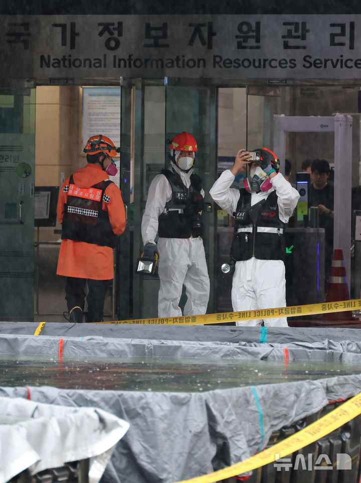 [대전=뉴시스] 강종민 기자 = 28일 화재가 완진된 대전 유성구 국가정보자원관리원에서 화재조사팀이 외부 침수조에 냉각작업 중인 리튬이온 배터리를 살펴보고 있다. 2025.09.28. ppkjm@newsis.com