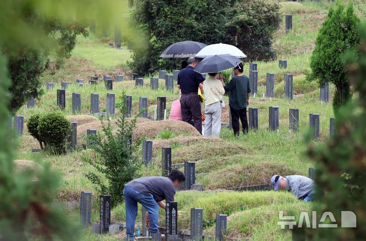  [부산=뉴시스] 하경민 기자 = 28일 부산 금정구 영락공원을 찾은 시민들이 비가 내리는 궂은 날씨 속에서 성묘와 벌초를 하고 있다. 2025.09.28. yulnetphoto@newsis.com
