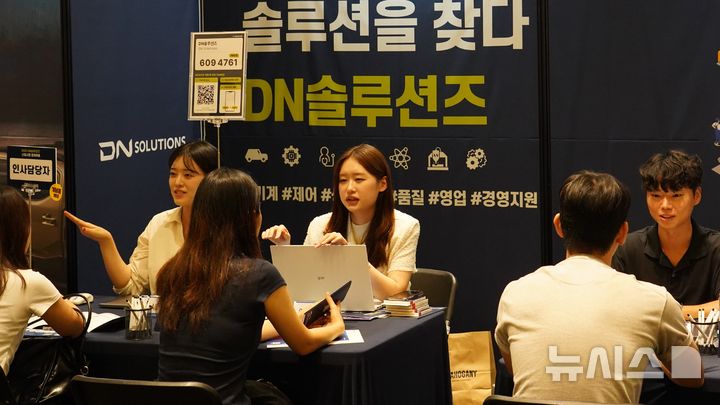 [서울=뉴시스]지난 3일 서울 연세대학교에서 열린 채용박람회에서 DN솔루션즈 직원들이 학생들과 하반기 공개채용 관련 상담을 하고 있다.(사진=DN솔루션즈 제공) 2025.09.29. photo@newsis.com