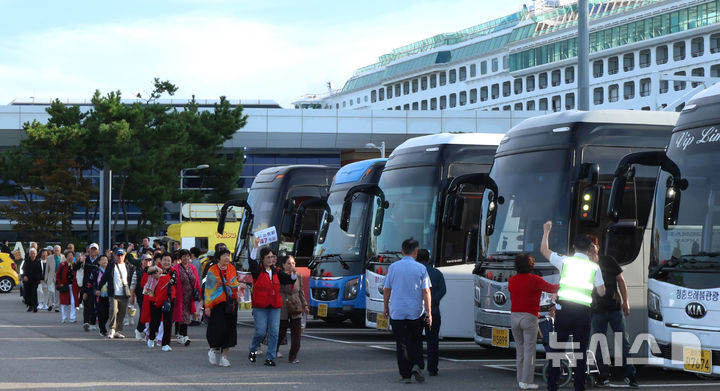 [인천=뉴시스] 전진환 기자 = 중국인 단체관광객에 대한 무비자 입국 시행 첫날인 29일 오전 인천 연수구 인천항 크루즈터미널에서 중국인 단체 크루즈 관광객이 입국해 버스로 향하고 있다. 2025.09.29. amin2@newsis.com