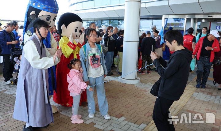 [인천=뉴시스] 전진환 기자 = 중국인 단체관광객에 대한 무비자 입국 시행 첫날인 29일 오전 인천 연수구 인천항 크루즈터미널에서 중국인 단체 크루즈 관광객이 입국해 기념촬영을 하고 있다. 2025.09.29. amin2@newsis.com