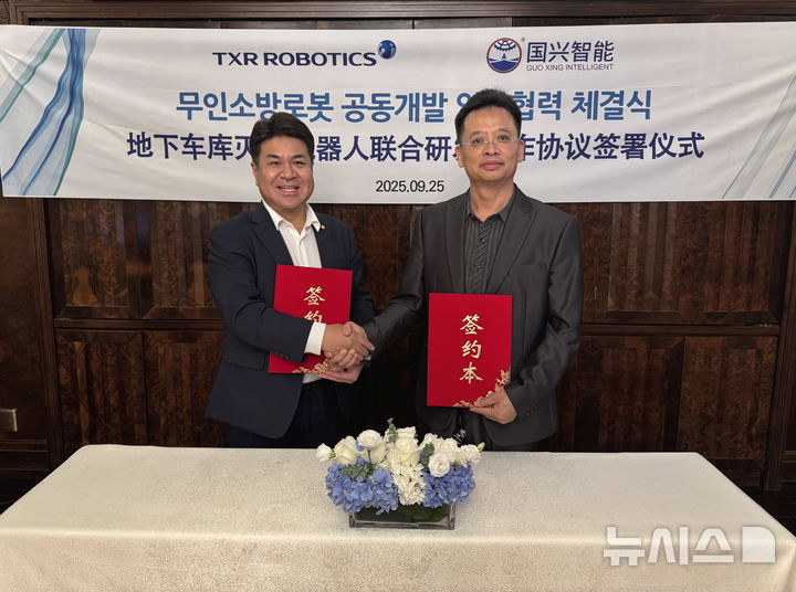 [서울=뉴시스] 엄인섭 티엑스알로보틱스 대표이사(왼쪽)와 바오밍송(Bao MingSong) 궈싱즈넝(国兴智能∙GuoXing Intelligent) CEO(오른쪽)가 25일 중국 상하이에서 ‘무인 소방로봇 공동개발 및 상업화 업무협력’협약을 체결한 뒤 기념촬영을 하고 있다. (사진=유진그룹 제공)