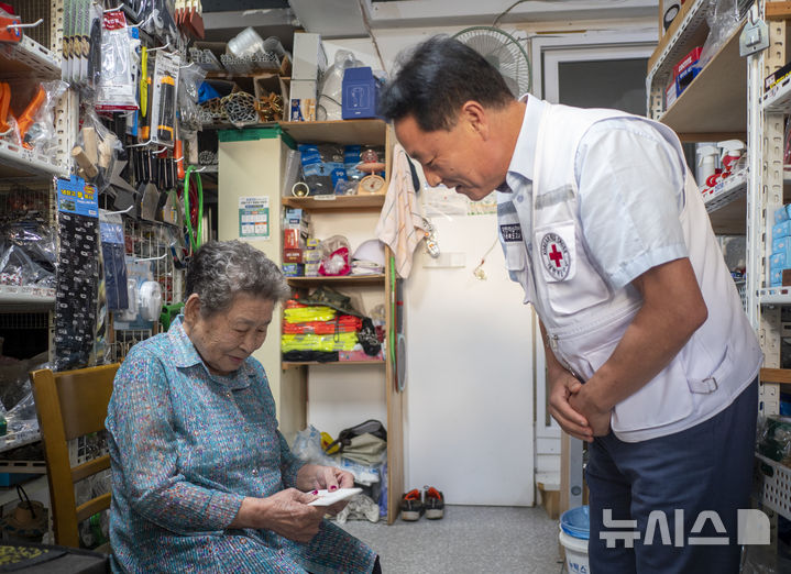 [전주=뉴시스] 강경호 기자 = 29일 전북 전주시 덕진구 진북동의 한 철물점에서 고령 이산가족인 박복주 할머니(왼쪽)을 위해 김한규 대한적십자사 전북특별자치도지사 사무처장이 추석 기념 용돈을 전달하고 있다. 2025.09.29. lukekang@newsis.com