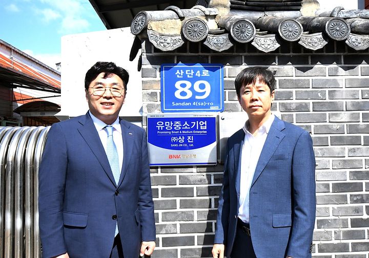 [울산=뉴시스] 30일 BNK경남은행 황재철 부행장이 ㈜상진 이동욱 대표에게 유망중소기업 인증서와 현판을 전달하고 있다. (사진=경남은행 제공) 2025.09.30. photo@newsis.com *재판매 및 DB 금지