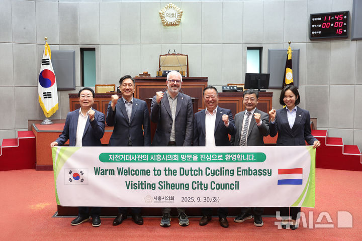 [시흥=뉴시스] 시흥시의회 도시환경 위원회가 최근 네덜란드 자전거대사관과 간담회를 연 가운데 참석자들이 기념 촬영을 하고 있다. (사진=시흥시 의회 제공).2025.10.01.photo@newsis.com