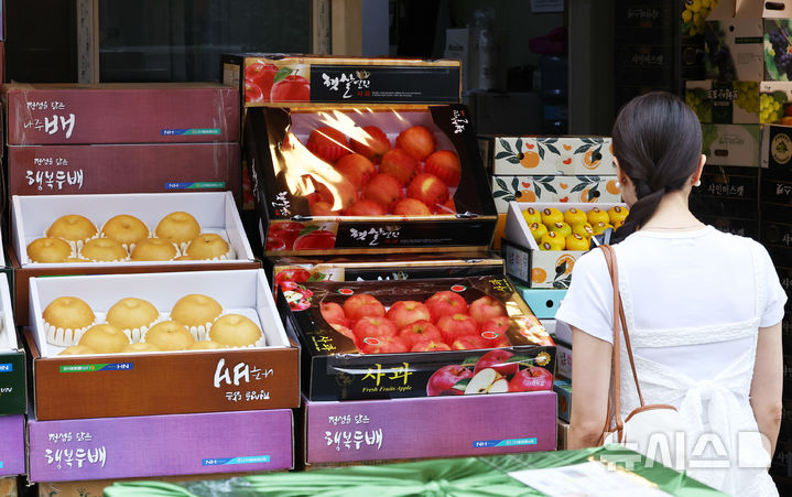 [서울=뉴시스] 최진석 기자 = 지난 30일 서울 중구 중부시장 인근 청과물 상점에서 고객이 과일을 고르고 있다. 2025.09.30. myjs@newsis.com