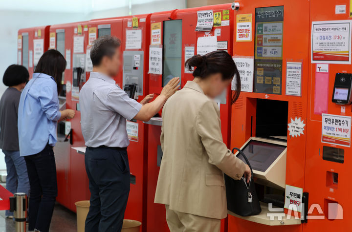 [서울=뉴시스] 홍효식 기자 = 국가정보자원관리원 화재로 닷새째 정부 행정전산망에 마비된 가운데 복구 작업이 이뤄지고 있는 30일 서울 서초구 서울법원청사 우체국에서 시민들이 복구된 무인우편접수기를 이용하고 있다. 2025.09.30. yesphoto@newsis.com