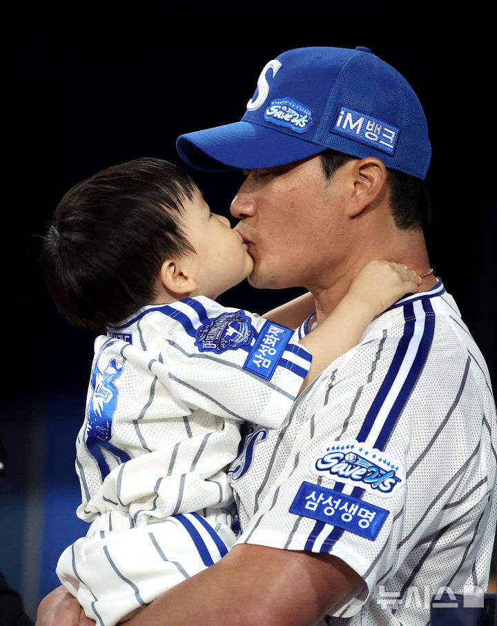 [대구=뉴시스] 이무열 기자 = 30일 대구 수성구 삼성라이온즈파크에서 열린 2025 신한 SOL 뱅크 KBO리그 KIA 타이거즈와 삼성 라이온즈 경기에 앞서 시구·시포를 준비하던 삼성 오승환이 아들과 입맞춤하고 있다. 2025.09.30. lmy@newsis.com