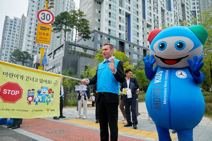 [서울=뉴시스] 메르세데스-벤츠 사회공헌위원회가 경찰청과 손잡고 이달 31일까지 어린이 안전벨트 착용 생활화를 위한 교통안전 캠페인을 펼친다. 사진은 지난달 30일 서울 서대문구 인왕초등학교 앞에서 교통지도를 하고 있는 마티아스 바이틀 메르세데스-벤츠 코리아 대표 모습. (사진=벤츠 코리아 제공) 2025.10.01 photo@newsis.com *재판매 및 DB 금지