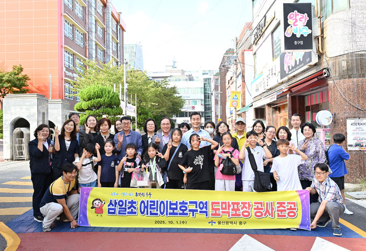 [울산=뉴시스] 구미현 기자 = 1일 김영길 울산 중구청장과 관계 공무원, 삼일초등학교 교직원, 지역 주민 등 20여 명은 삼일초 일대에서 도막 포장 공사 현장을 살펴보고 기념 촬영을 하고 있다. (사진=울산시 중구 제공) 2025.10.01. photo@newsis.com *재판매 및 DB 금지