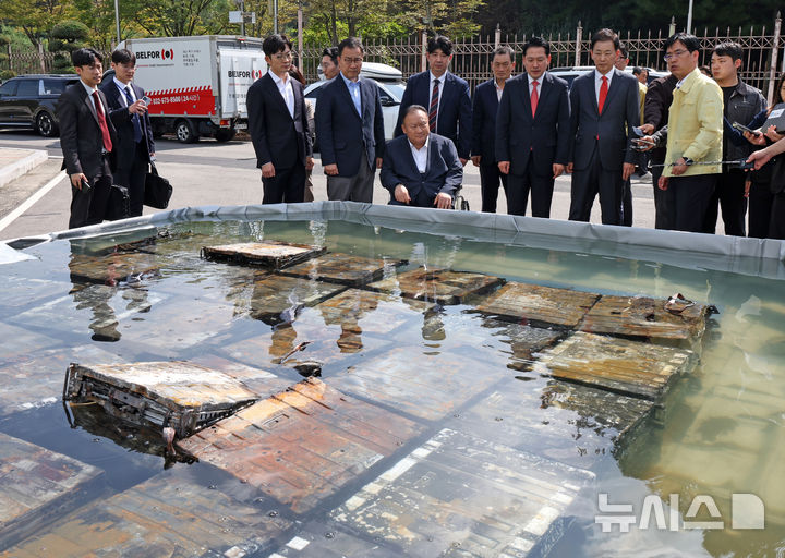[대전=뉴시스] 김금보 기자 = 장동혁 국민의힘 대표가 1일 오후 대전 유성구 국가정보자원관리원 화재현장에서 외부 침수조에 냉각작업 중인 리튬이온 배터리를 살펴보고 있다. 2025.10.01. kgb@newsis.com