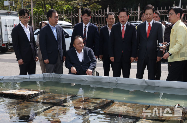 [대전=뉴시스] 김금보 기자 = 장동혁 국민의힘 대표가 1일 오후 대전 유성구 국가정보자원관리원 화재현장에서 외부 침수조에 냉각작업 중인 리튬이온 배터리를 살펴보고 있다. 2025.10.01. kgb@newsis.com
