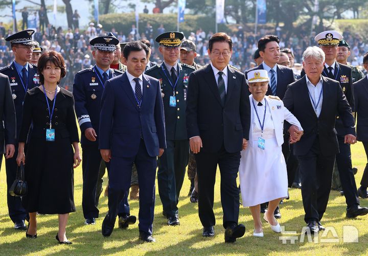 [계룡=뉴시스] 고범준 기자 = 이재명 대통령이 1일 충남 계룡대에서 열린 건군 77주년 국군의 날 기념식에서 7인의 국민대표, 모범 장병, 군 지휘부들과 함께 입장하고 있다. 2025.10.01. bjko@newsis.com