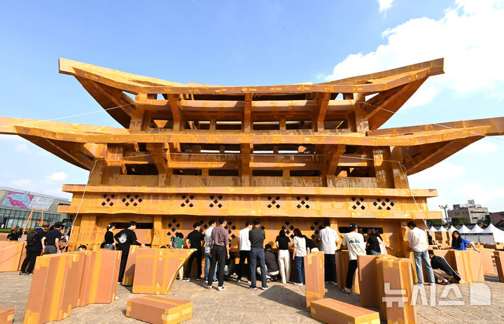 [수원=뉴시스] 김종택 기자 = 제62회 수원화성문화제가 열린 1일 경기 수원시 화성행궁 광장에 시민들이 종이 박스로 제작한 수원화성 팔달문이 전시돼 있다. 종이박스를 자르고 조립하며 제작한 팔달문은 가로와 세로가 각각 18.68m, 13.87m에 높이는 11.73m로 실제 크기의 60% 규모다. 2025.10.01. jtk@newsis.com