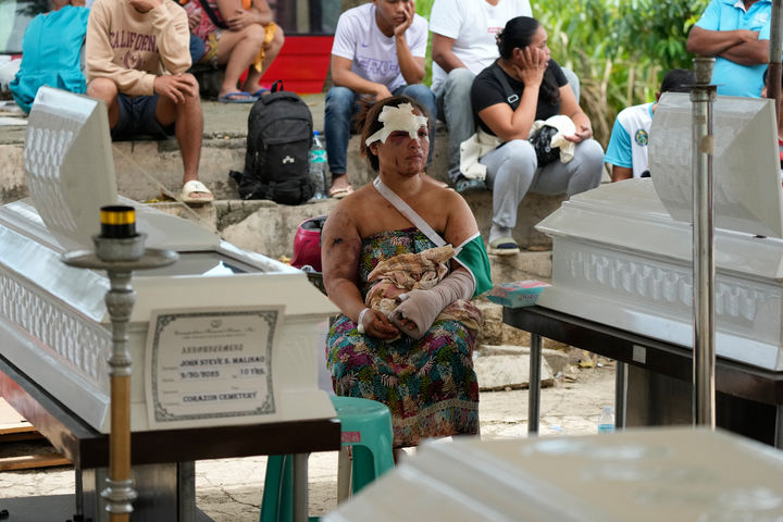 [보고=AP/뉴시스] 2일(현지 시간) 필리핀 세부주 보고에서 강진으로 부상한 여성이 두 아들 관 옆에 앉아 슬픔을 달래고 있다. 이 여성은 지난달 30일 발생한 규모 6.9의 강진으로 산사태가 발생하면서 언덕에 있던 집들이 무너져 두 아들을 잃고 자신은 부상한 채 살아남았다. 2025.10.02.