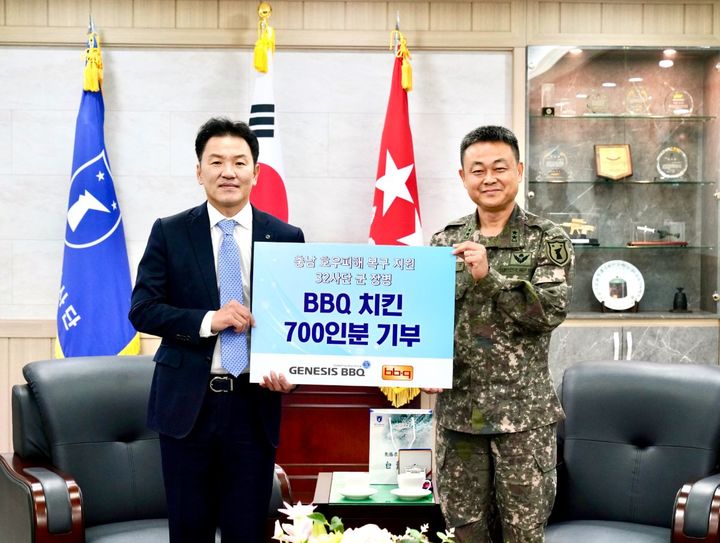 [서울=뉴시스] BBQ가 국군의 날을 맞아 육군 제32보병사단에 치킨박스 700인분을 전달했다. (왼쪽부터) 김지훈 BBQ 대표이사와 김지면 32사단장이 기념 촬영을 하고 있다. (사진=제너시스BBQ 제공) *재판매 및 DB 금지
