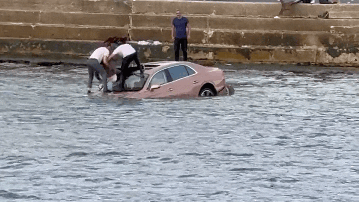 [뉴시스]30일(현지시간) 영국 샌드뱅크스 항구에서 자신의 벤틀리 차량과 함께 추락한 로버트 힐 씨를 선루프를 통해 구출하고 있다. (사진=데일리메일) 2025.10.01 *재판매 및 DB 금지