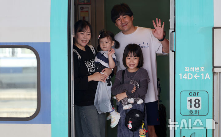 [서울=뉴시스] 김선웅 기자 = 추석 연휴를 하루 앞둔 2일 서울역에서 귀성객들이 열차에 탑승하며 손을 흔들어 인사하고 있다. 2025.10.02. mangusta@newsis.com