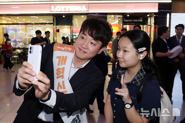 [서울=뉴시스] 김명년 기자 = 이준석 개혁신당 대표가 2일 오전 서울 용산구 서울역에서 추석 귀성인사를 하던 중 한 시민과 셀카를 찍고 있다. 2025.10.02. kmn@newsis.com