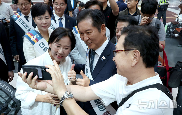 [서울=뉴시스] 김금보 기자 = 정청래 더불어민주당 대표 및 지도부가 2일 오전 용산역을 찾아 귀성길에 나선 시민들과 셀카를 찍고 있다. (공동취재) 2025.10.02. photo@newsis.com