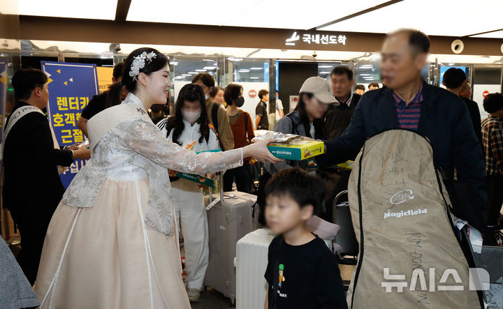 [제주=뉴시스] 우장호 기자 = 2일 오후 제주국제공항 1층 도착장에서 열린 추석 연휴입도 관광객 환영행사에서 국내·외 이용객들에게 제주삼다수와 먹거리를 나눠주고 있다. 2025.10.02. woo1223@newsis.com