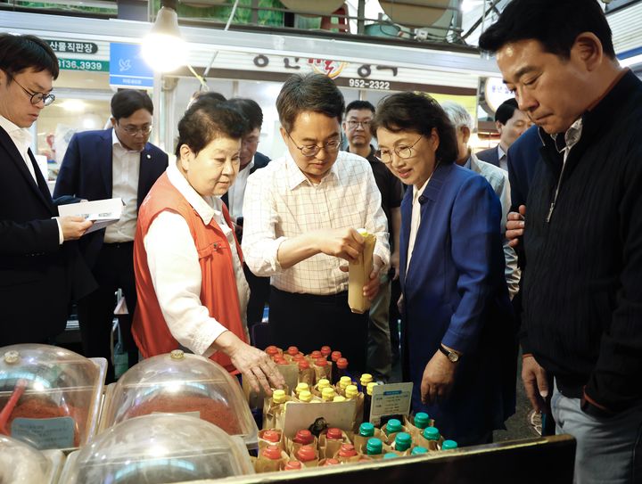 [수원=뉴시스] 김동연 경기도지사가 추석 연휴 첫날인 3일 파주 문산자유시장을 방문해 물품을 직접 구입하고 있다. (사진=경기도 제공) 2025.10.03. photo@newsis.com *재판매 및 DB 금지