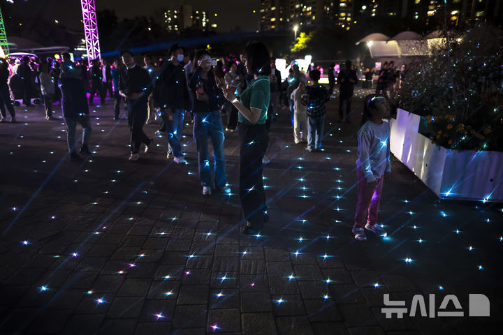 [서울=뉴시스] 정병혁 기자 = 3일 서울 광진구 뚝섬한강공원에서 열린 2025 서울라이트 한강 빛섬축제를 찾은 시민들이 라이트 전시를 살펴보고 있다. 2025.10.03. jhope@newsis.com