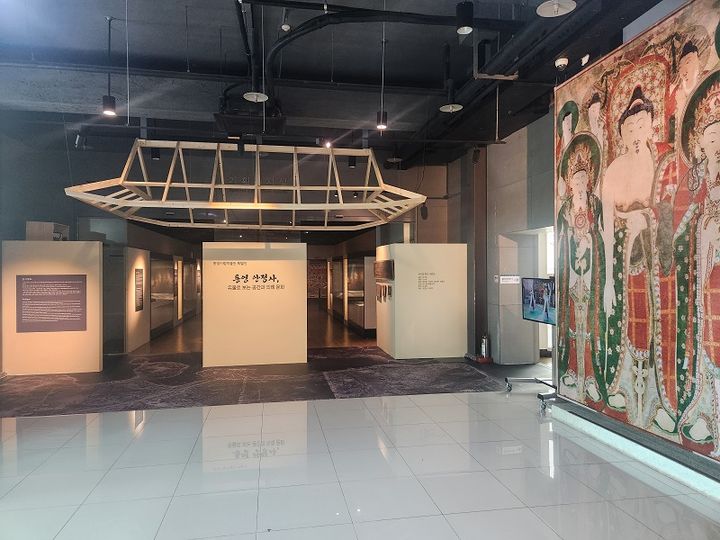 [통영=뉴시스] 신정철 기자= 경남 통영시는 지난 2일 통영시립박물관 기획전시실에서 '통영 안정사, 유물로 보는 공간과 의례 문화 展' 개막식을 개최했다.사진은 영조 28년에 제작된 것으로 추정, 2001년 도난당했다가 2014년 한 경매에 나왔다가 회수된 삼세불도 전시 모습.(사진=통영시 제공).2025.10.04. photo@newsis.com *재판매 및 DB 금지